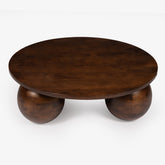 Wooden coffee table with three spherical legs on a white background